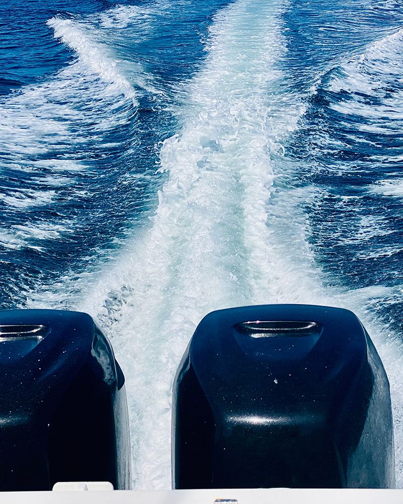 Primer plano de unos motores dejando una estela en el mar.