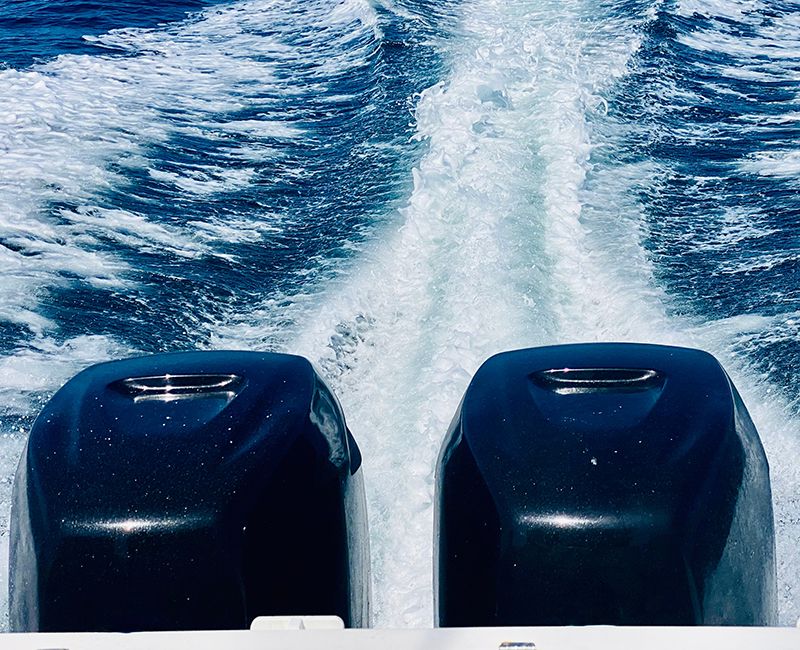 Primer plano de unos motores dejando una estela en el mar.
